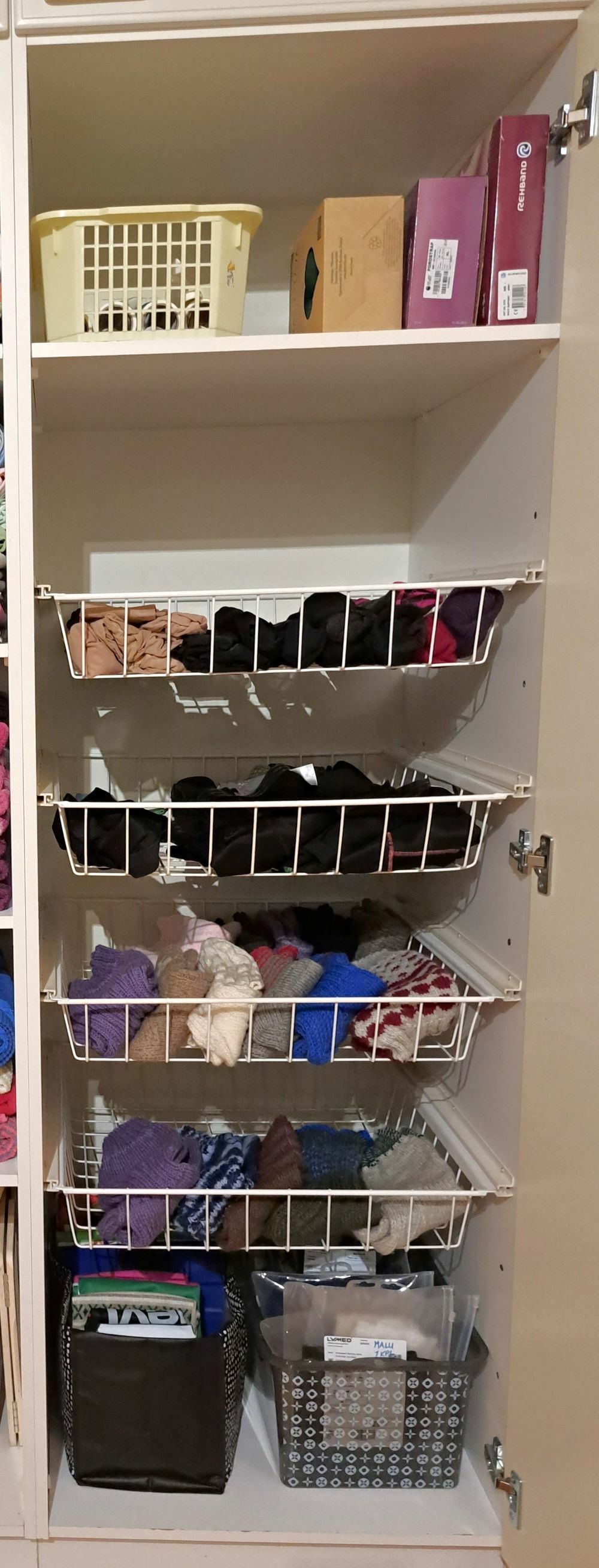 Korikaapin tavaroista on karsittu yli puolet pois ja jäljelle jääneet sukat, kassit ja tavarat on järjestetty toimivaan järjestykseen.