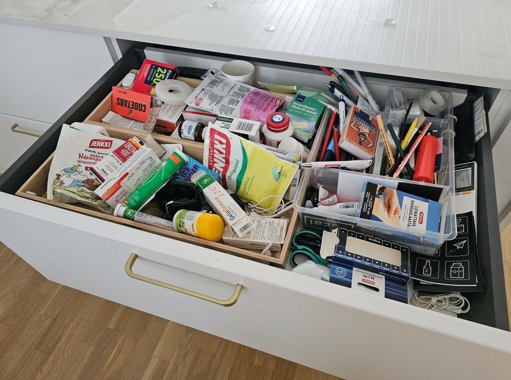 Keittiön sekatavaralaatikko on täynnä ja sekaisin erilaista tavaraa.